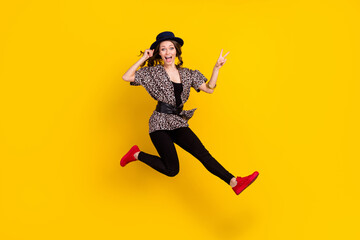 Fototapeta na wymiar Full body photo of crazy excited young woman jump up show v-sing isolated on yellow color background