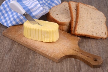 Beurre sur une planche à découper avec un couteau planté dedans à côté de tranches de pain de mie
