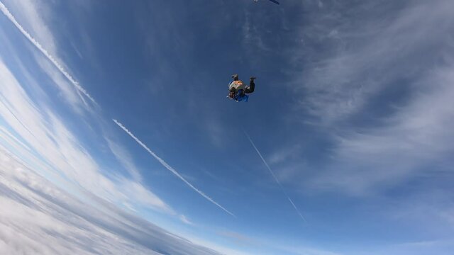 Skydiving. Tandem jump. A young woman and her instructor are flying in the sky.