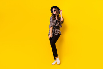 Fototapeta na wymiar Full length photo of charming nice pretty young woman wear hat sunglass isolated on shine yellow color background