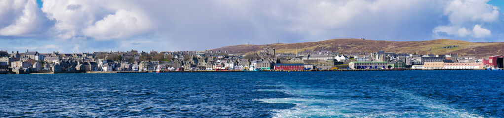 Across Bressay Sound, a view of Lerwick, the main town and port of the Shetland Islands, Scotland, UK - taken on a sunny day with blue sky and white clouds.