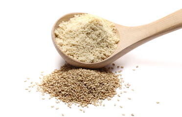Organic sesame protein powder and grains pile with wooden spoon isolated on white background