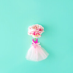 Pink roses in a dress. Minimal aesthetic composition. On a blue background. Flower like a ballerina.