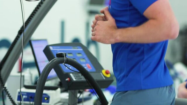 Man athlete going trough the Vo2 Max testing on treadmill in modern sport science lab. triathlete workout testing endurance preparing to the race. Professional sport analyzing