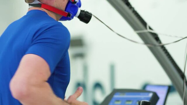 Man athlete going trough the Vo2 Max testing on treadmill in modern sport science lab. triathlete workout testing endurance preparing to the race. Professional sport analyzing