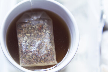 White cup with infusion and tea bag