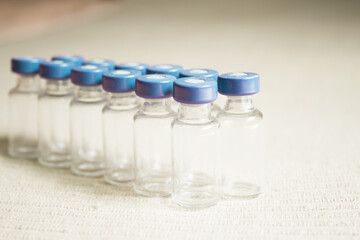 Empty glass jars of coronavirus vaccines