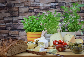 cheeseboard with camenbert, blue cheese, cheese with herbs and pepper and more