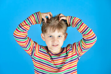 The child scratches his head from lice with all his might.