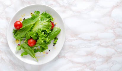 Top view of plate of healthy fresh salad.Tomatoes,spinach,lettuce leaves, ghee butter.Empty space