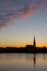 Fototapeta na wymiar Coucher de soleil sur Bordeaux : vue sur la Garonne et la basilique Saint Michel