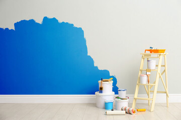 Decorator's kit of tools and paints near light wall indoors