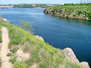 Fototapeta na wymiar Panorama from above of the azure water surface of the old Dnieper riverbed that washes the rocky shores of the island of Khortytsia.