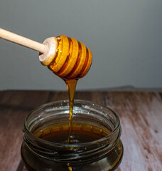 Wooden Honey Dipper Drizzling Honey