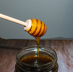 Wooden Honey Dipper Drizzling Honey