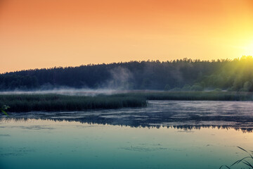 Early morning. Sunrise over the lake. Summer rural landscape
