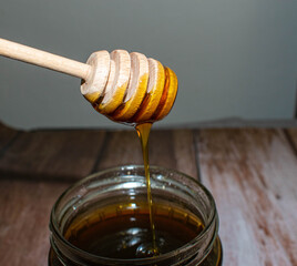 Wooden Honey Dipper Drizzling Honey
