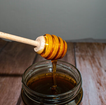 Wooden Honey Dipper Drizzling Honey