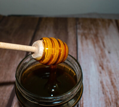 Wooden Honey Dipper Drizzling Honey