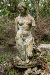 Becej, Serbia - May 01, 2021: The summer house of the noble family Gombos and a fountain in the shape of a bust of a young woman left to the ravages of time.