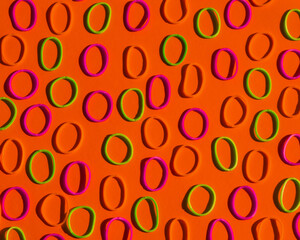 Pattern of colorful rubber bands on red background. Office utensils concept. Loom bands. Minimalist red background. Office layout or template, office equipment. Circle geometric pattern, vibrant color
