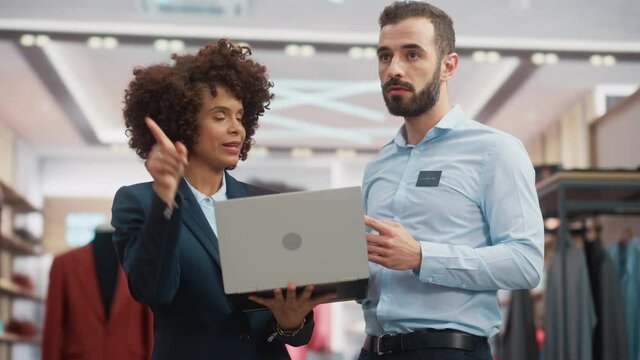 Clothing Store: Businesswoman Uses Tablet Computer, Talks to Visual Merchandising Specialist, Collaborate To Create Stylish Collection. Small Business Fashion Shop Sales Manager Talks to Designer.