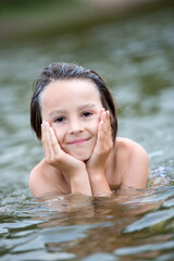 Fototapeta premium Beautiful portrait of child in lake, kid playing