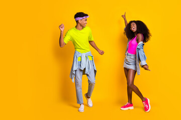 Fototapeta na wymiar Photo of attractive charming young people wear jeans clothes dancing looking each other isolated yellow color background