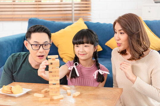 Happy Asian family having fun playing block game in the living room at home.