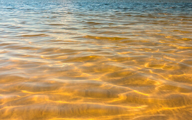 Fototapeta na wymiar water texture with waves. sea waves with sun glare.
