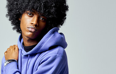 Portrait of young handsome black man in hoodie with afro hair