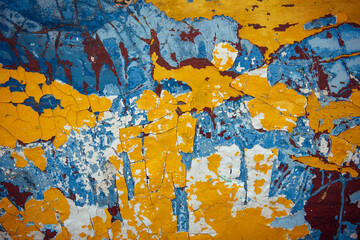 Yellow, blue, white, brown abstract vintage background. Old peeling paint on the wood surface, weathered texture.
