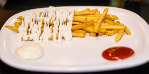 French fries with mayonnaise and tomato ketchup.