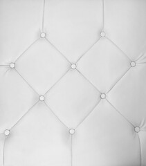 Closeup of white leathern sofa. The one of decorative designs for using as background and texture.