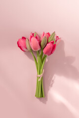 Bouquet of pink tulips on pink background. Vertical orientation.