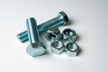 group of bolts and nuts made of light metal on a white background