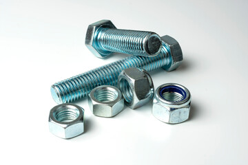 group of bolts and nuts made of light metal on a white background