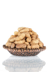 Heap of peanuts in the shell in a wooden plate. Isolated