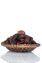 Heap of dry dates in a wooden plate. Isolated