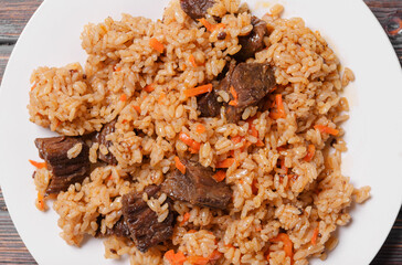 Uzbek pilaf with meat on a white plate  top view