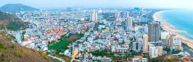 Fototapeta na wymiar Aerial view on Vung Tau, Vietnam which is the popular beach city. There are crowded small building close to the sea and mountain.