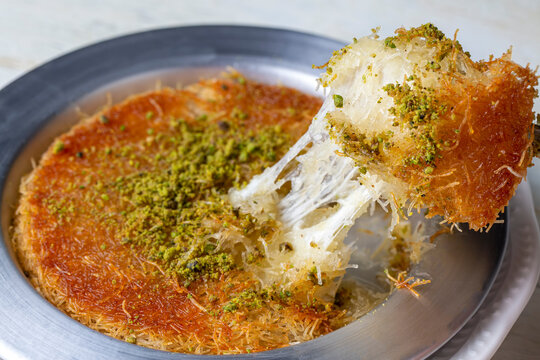 Delicious traditional Turkish kunefe with pistachio on it. Served hot and with syrup