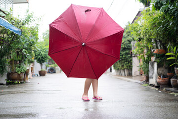 A little girl holding a red umbrella stood in the middle