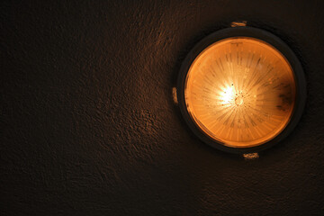 Old style yellow color lamp and illumination and reflection of the light on the concrete and plaster wall