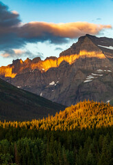 Obraz premium dramatic summer sunrise in Swift Current Lake in Many Glacier area in Glacier National park with the Grinnell Mt being illuminated by the sunrise .