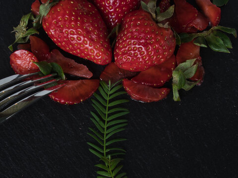 Ripe strawberries with shiny metal fork