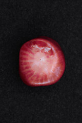 Red coral jewel stone texture on black background. Macro closeup.