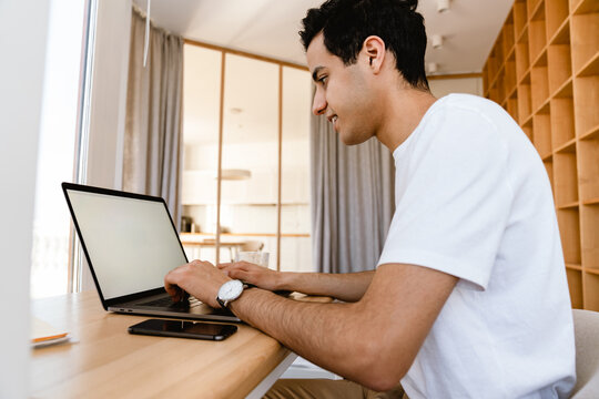 Smiling Young Hispanic Man Working Studying On Laptop