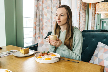 young beautiful woman have breakfast in cafe