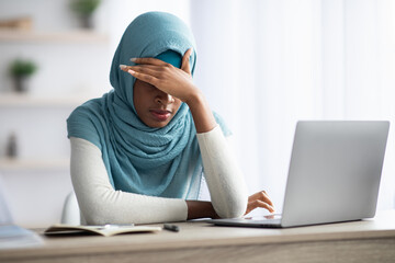 Deadline Stress. Black Muslim Lady Tired After Working With Laptop At Home